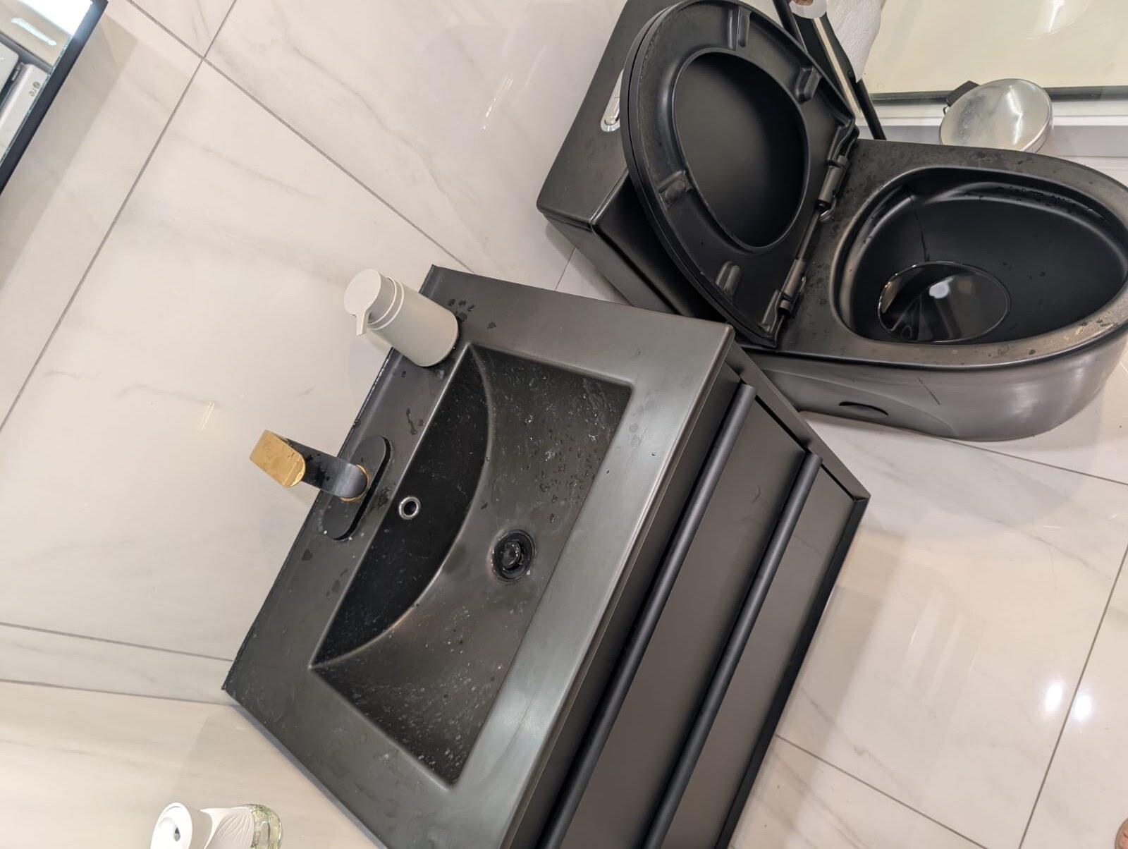 Bathroom before cleaning, with soap scum, clutter, and water stains